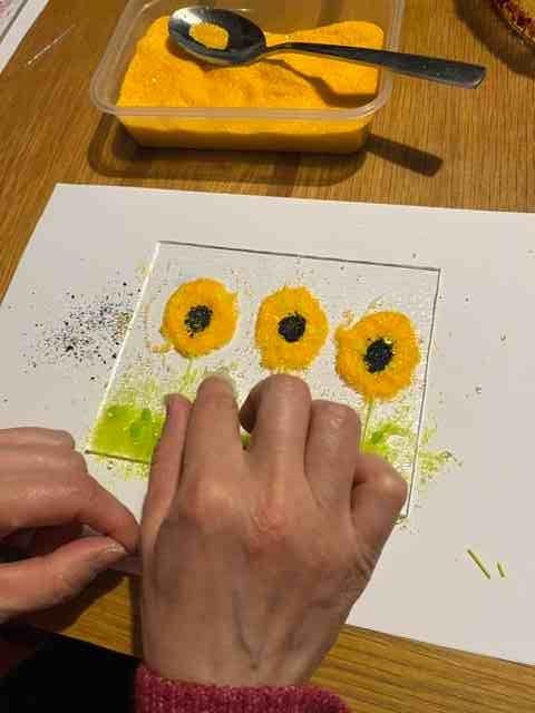 Hands shaping glass at a workbench during a glass-making session